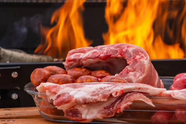 Sosis, tavuk budu, domuz pastırması, domuz kaburgası, sosis ve sebzelerle birlikte açık havada ızgarada kızartılmış et, odun ateşi ve mangal kömürü, duman..