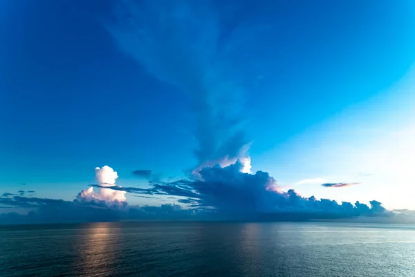 sunset over blue ocean, sky with clouds.