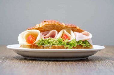 Jambon, peynir ve sebzeyle dolu kruvasan..