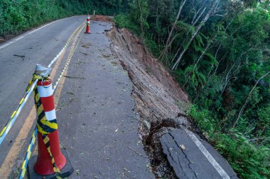 Bir dağ bölgesindeki heyelan yüzünden asfalt yol hasar gördü.