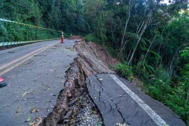 asphalt road damaged by a landslide in a mountain area. clipart