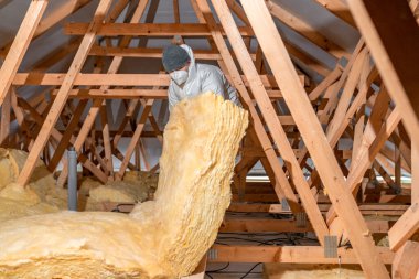 insulation of the house under the roof with the help of glass wool. 