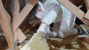 insulation of the house under the roof with the help of glass wool. 