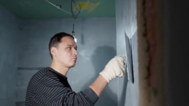 man applies insulation to a bathroom wall. 