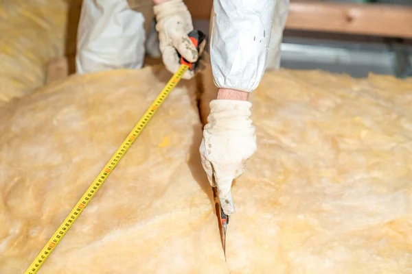 cutting glass wool when insulating the ceiling on the roof.