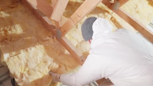 Ein Mann Dämmt Dach Und Decke Des Hauses Mit Glaswolle — Stockvideo