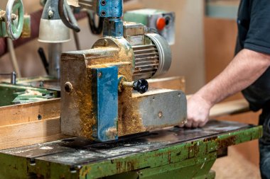 planing boards on a machine in a joinery. 