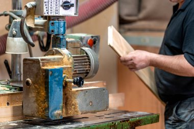 planing boards on a machine in a joinery. 