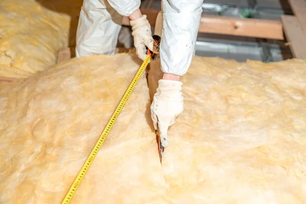 cutting glass wool when insulating the ceiling on the roof.