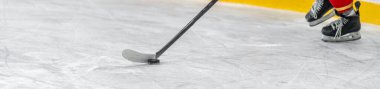 hockey player with a puck on a hockey stick in a game on ice. banner with copy space. High quality photo clipart