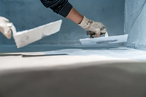 stock image work with trowel on floor and wall in new room in building. High quality photo