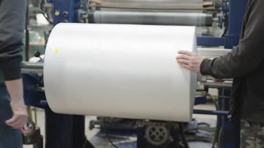 changing the plastic roll on the machine in the factory. 