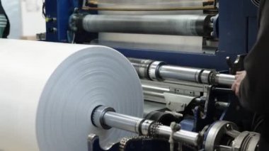 changing the plastic roll on the machine in the factory. 