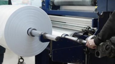 changing the plastic roll on the machine in the factory. 