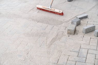 Yeni kaldırımdaki boşlukları kumla dolduruyor.. 