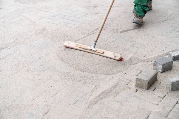 Yeni kaldırımdaki boşlukları kumla dolduruyor.. 