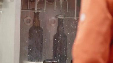 Bira fabrikasındaki bira şişelerini otomatik dolduran bir makine. Yüksek kaliteli video