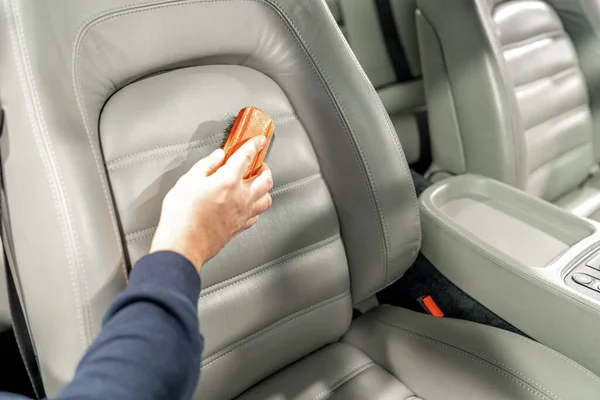 stock image cleaning leather car seats with a brush and chemicals. 