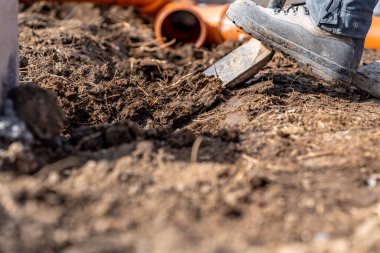 Su ve atık için plastik borular için toprağı kazıyoruz.. 