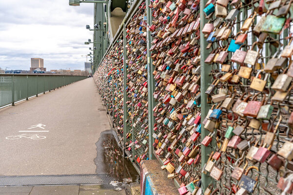 Cologne, Germany - March 23, 2023: metal bridge with padlocks. a symbol of closed partnership and love. High quality photo