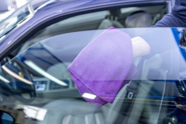 Garajda mikrofiber havluyla araba camlarının elle temizlenmesi. Yüksek kalite fotoğraf