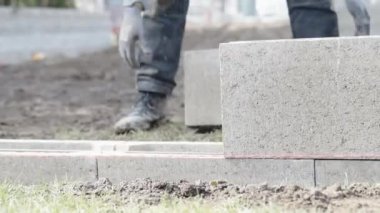 Zanaatkar ev inşa ederken beton döşeme taşır. 