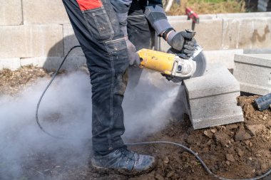 Elektrikli öğütücüyle beton tuğla kesiyor.. 