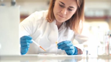 Genç kadın bilim adamı bir araştırma laboratuvarında kimyasal deneyler yapıyor.. 