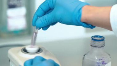 Kimyasal numuneyi bir cam ölçü kabında otomatik bir makinenin yardımıyla karıştırmak. Yüksek kalite 4k görüntü