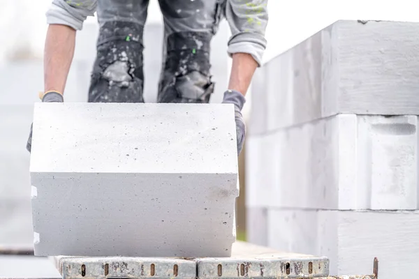 stock image a mason builds the wall of a house from concrete blocks. High quality photo