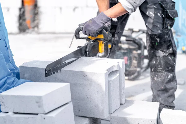 cutting concrete blocks with a saw during the construction of a building wall.