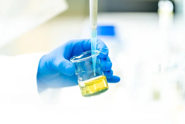 Stock image pipetting a chemical sample into research flasks. High quality photo