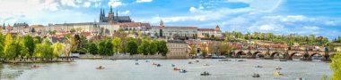 Çek Cumhuriyeti 'nin başkenti Prag' ın panoramik manzarası. Prag Kalesi ve Charles Köprüsü manzarası. Yaz zamanı, insanlar katamaranların üzerinde yüzer. Yüksek kalite fotoğraf