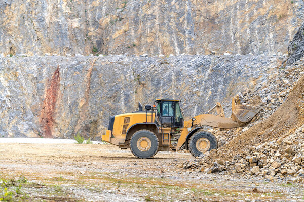 Excavator mines stone in quarry. High quality photo