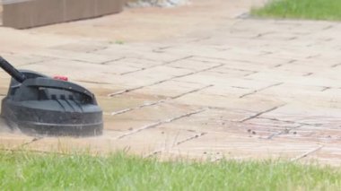 Evin önündeki beton kaldırımı fırçayla temizleyen bir makine. Yüksek kaliteli video