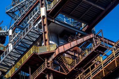 Yıpranmış metal sanayi binası zamanın ve havanın etkilerini gösteriyor. Paslı çelikten yapılmış bir zemin mavi gökyüzünün altında. Eski moda cazibe ve tarih yayılıyor.