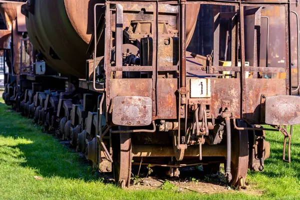 Unutulmuş sanayi bölgesinin yemyeşil çimlerinde çürüyen paslı tren vagonları nostaljik bir manzara yaratıyor. Yıllanmış metal, soyulmuş boya, paslı çelik standı terk edilmiş, ulaşım geçmişini anımsatıyor.