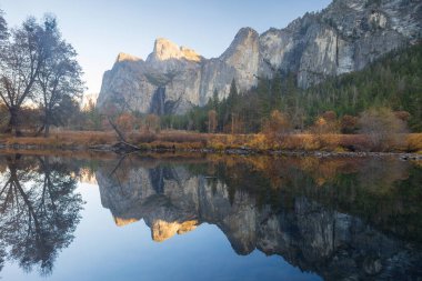 Sonbahar günbatımında Vadi Manzarası üzerinden Merced Nehri 'ne yansıyan Katedral Kayaları. Yosemite Ulusal Parkı, Kaliforniya, ABD.