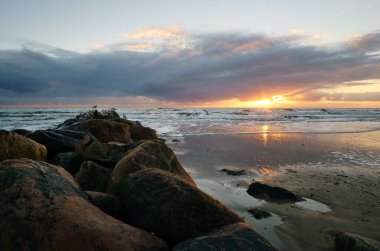 Danimarka sahilinde gün batımı. Stone Groyne ön planda. Sahilde kumda yürü. Deniz kenarındaki manzara fotoğrafı.