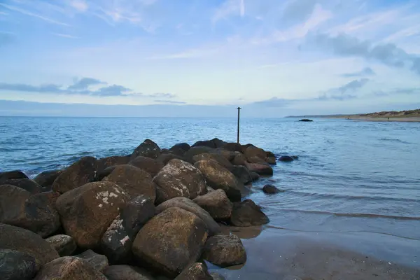 石のグラインはデンマークの海岸から水の中に出ています 晴れた日 海の風景写真 — ストック写真