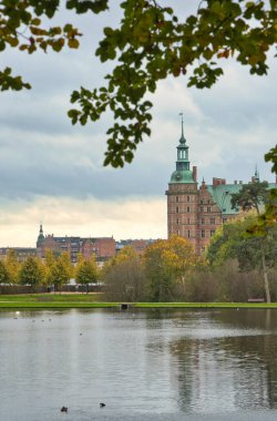 Frederiksborg kale parkının arka planında göl var. Yaprakların parlak renkleri. Danimarka 'da yürü
