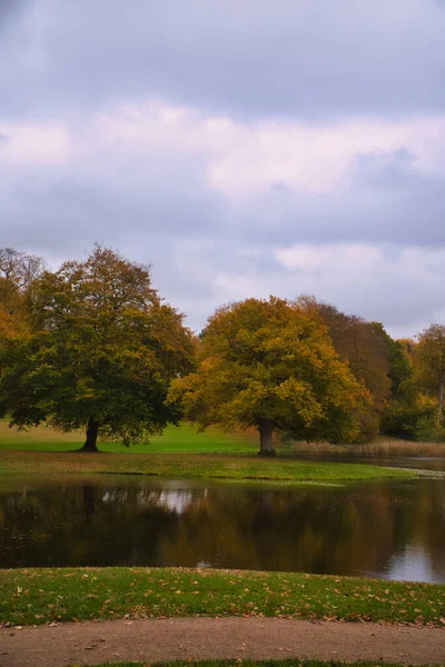 가을에는 프레데릭스 보르그 공원에 낙엽수들이 호수에 나무들 반사된다 덴마크에서 — 스톡 사진