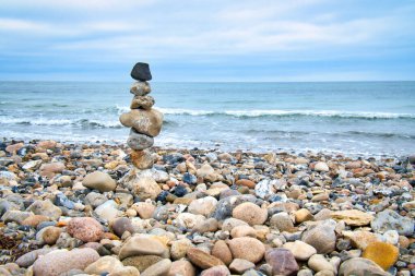 Sahilde denize bakan taş piramit. Danimarka kıyıları. İskandinavya manzara fotoğrafı