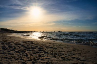 At sunset, the groynes jut into the sea. The sun shines on the Baltic Sea. Landscape from the coast