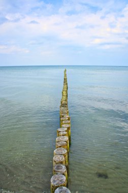 Groynes on the beach of the Baltic Sea in Zingst. calm water on the coast. They protect the coast of the German Baltic Sea from the waves.