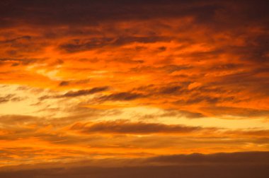 Background image with clouds in extreme colors of a sunset. The sky seems to burn. Photo from nature