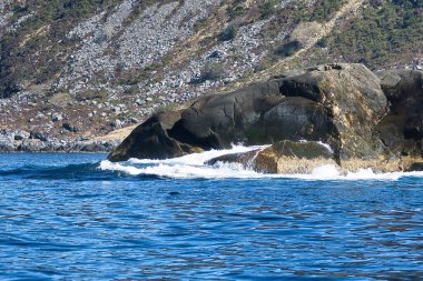 Fiyortta Norveç, kayalarda sprey. Taşlara su sıçrıyor. İskandinavya 'daki kıyı manzarası. Kuzeyden manzara fotoğrafı.