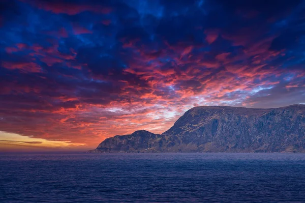 海からノルウェーの西の岬への眺めは 太陽の光と重い雲で日没です 前景の波 背景の岩 ヨーロッパ本土の西端点 — ストック写真