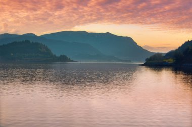 Norveç 'teki dağları ve fiyort manzaralı fiyort. Manzara akşam vakti kuzeyde gün batımında çekildi.