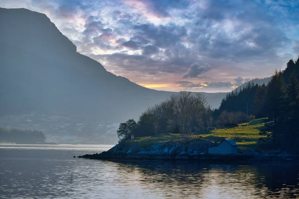 落日在挪威的峡湾与群山相连 在草地上散发出光芒和太阳光 斯堪的纳维亚景观 — 图库照片